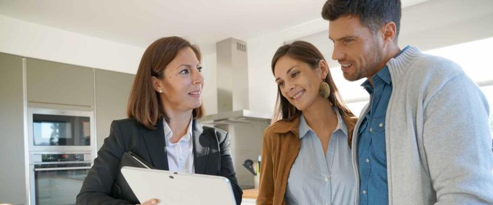 Couple with real-estate agent visiting house for sale