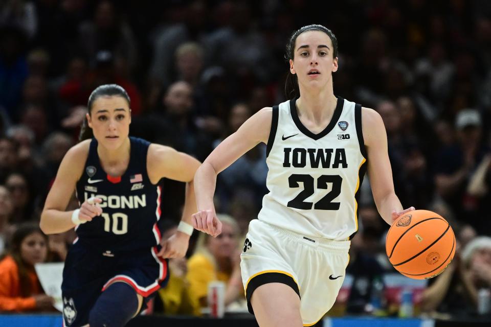 Caitlin Clark dribbles ahead of Nika Muhl during their Final Four matchup.