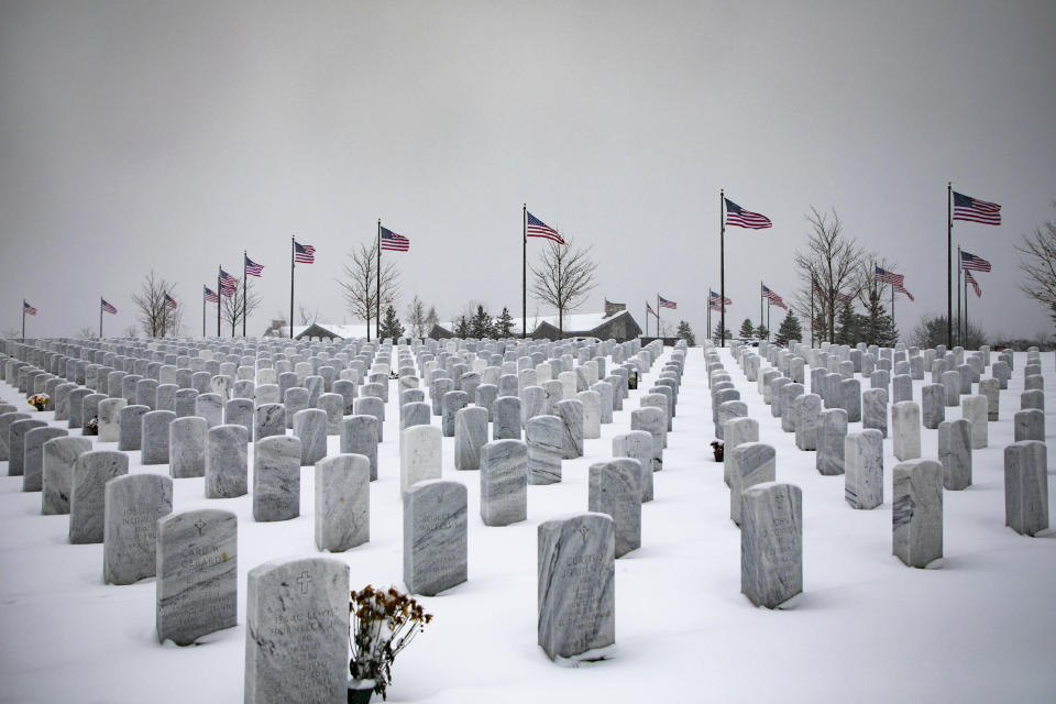 Snow covers graves where veterans are buried at The Great Lakes Cemetery on Monday, Nov. 11, 2019, in Holly, Mich. (Rachel Ellis/Saginaw News via AP)