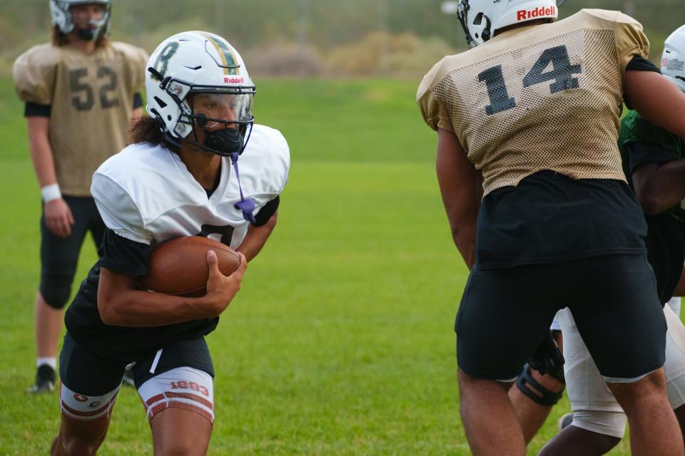 Junior quarterback, Demond Williams Jr. (left), practices with the Basha High School football team on the school's practice fields on Oct. 3, 2022, in Chandler, AZ.
