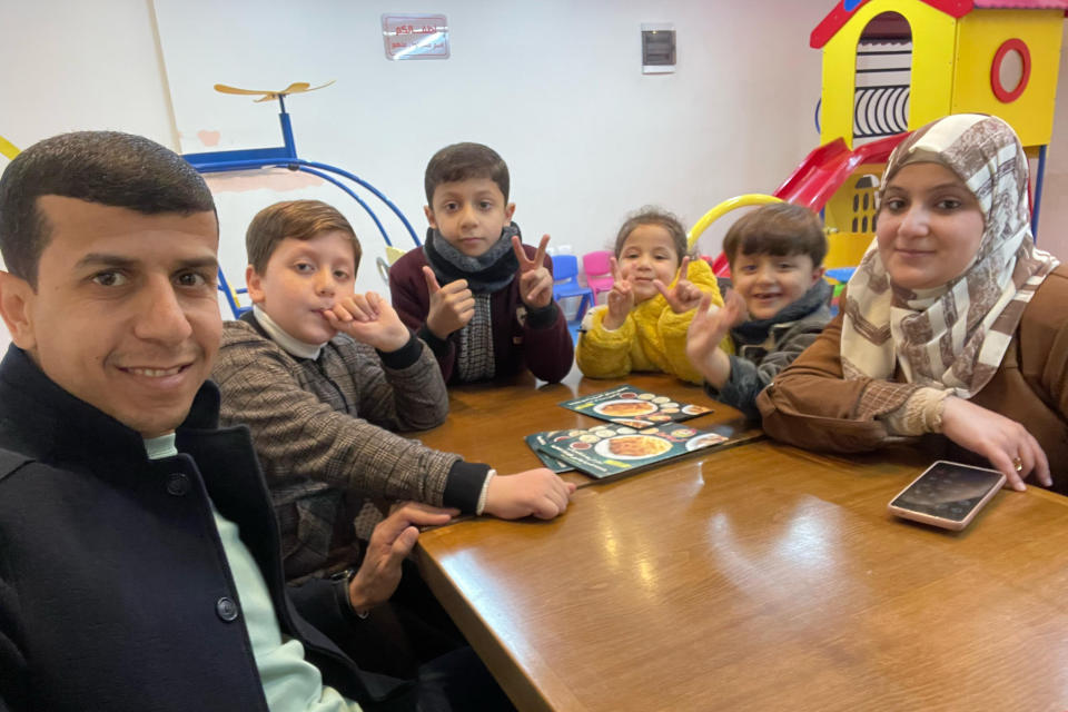 This photo provided by Ramzy Abu al-Qumssan, left, shows his family at a restaurant in Gaza in January 2023. From left, Ramzy Abu al-Qumssan; his sons, Ibrahim, and Mahmoud; his daughter, Nur; his son, Omar and his wife, Asmaa. Asmaa and Nur were killed in an airstrike on Nov. 16 in the Jabaliya refugee camp. (Courtesy Ramzy Abu al-Qumssan via AP)