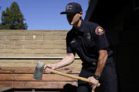 Fire engine probationary firefighter Cole Gomoll of Los Angeles County Fire Department - Station 106 demonstrates how to use a flathead ax at his station Friday, Feb. 26, 2021, in Rancho Palos Verdes, Calif, a suburb of Los Angeles. He used the ax to cut away the windshield of a vehicle crashed by golfer Tiger Woods on Tuesday. (AP Photo/Ashley Landis)