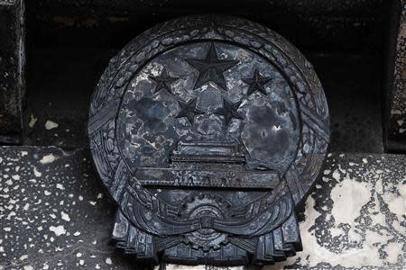 A charred national emblem of the People's Republic of China is seen outside the Chinese consulate after an unidentified person set fire to the main gate in San Francisco, California January 2, 2014. REUTERS/Stephen Lam