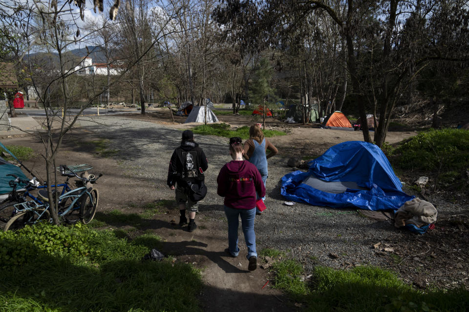 Cassy Leach, right, leads a group of volunteers to check on homeless people living in Baker Park on Thursday, March 21, 2024, in Grants Pass, Ore. (AP Photo/Jenny Kane)