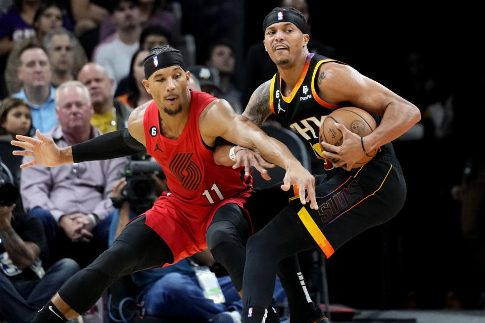 Phoenix Suns guard Damion Lee, spins around Portland Trail Blazers guard Josh Hart (11) during the first half of an NBA basketball game, Friday, Nov. 4, 2022, in Phoenix. (AP Photo/Matt York)