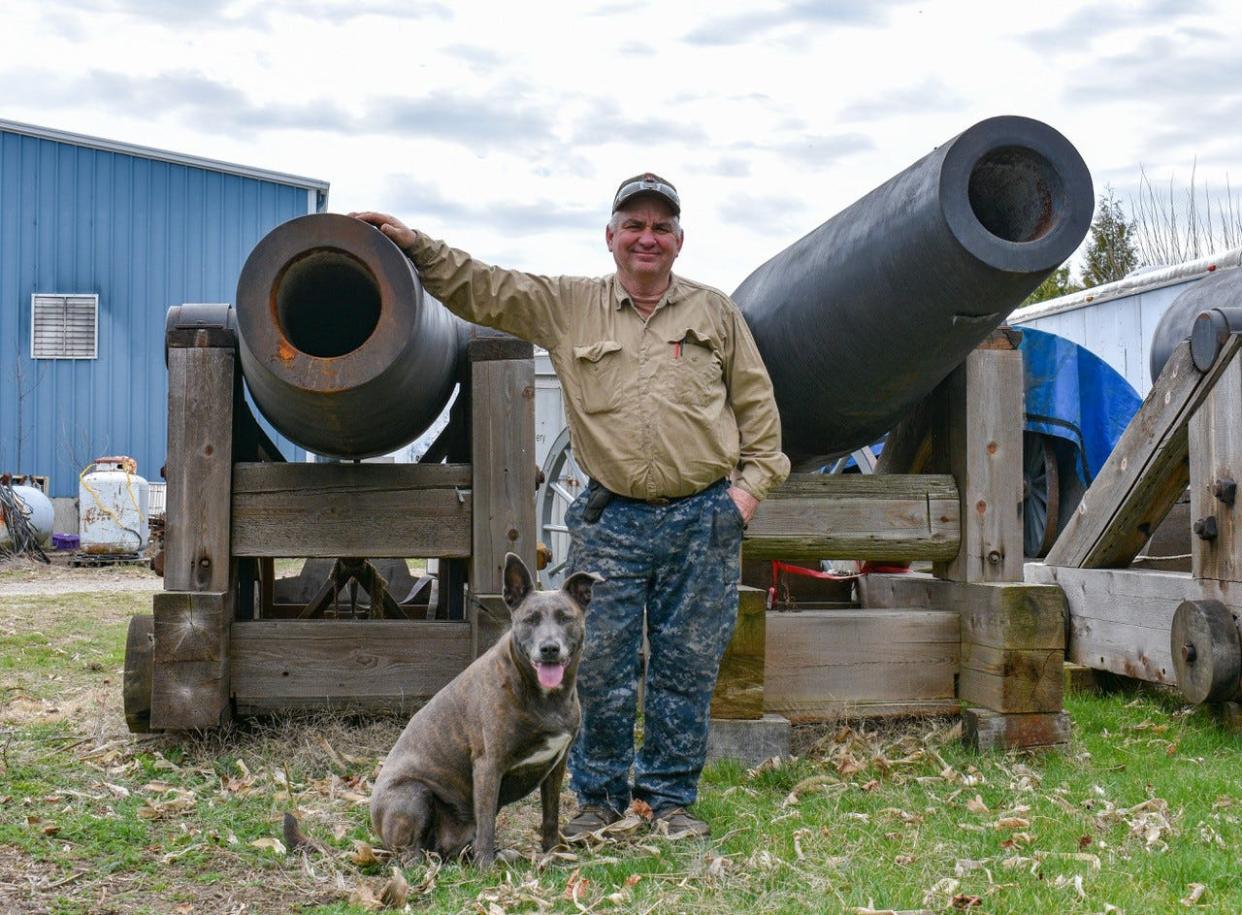 Bob Gillmor stands with his dog, Reggie, next to 10-inch Columbiad cannons that were used in the movie “Emancipation,” coproduced by and starring Will Smith.