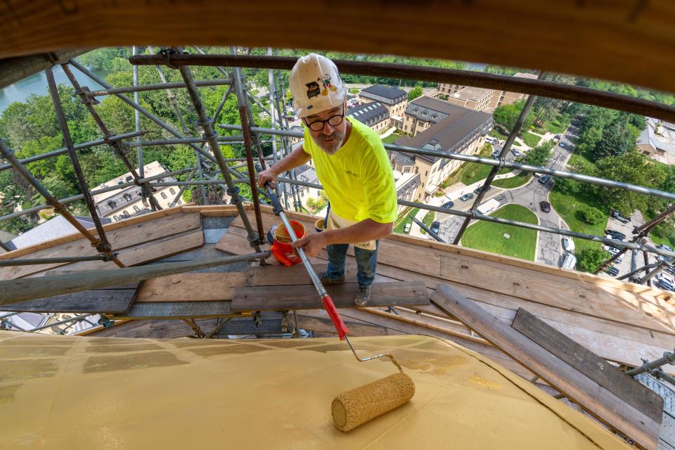Bryon Roesselet from Conrad Schmitt Studios applies a coat of gold primer on a section of the Golden Dome on the University of Notre Dame's Main Building in July.