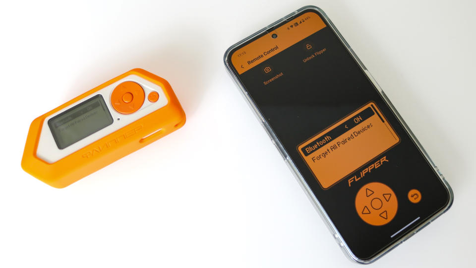 A Flipper Zero device next to a smartphone running the Flipper app