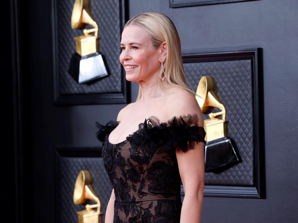 Chelsea in a black lace gown in front of a Grammys backdrop.
