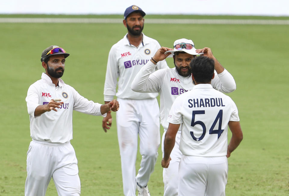 Indian captain Ajinkya Rahane, left, congratulates teammate Shardul Thakur after dismissing Australia's Tim Paine during play on day four of the fourth cricket test between India and Australia at the Gabba, Brisbane, Australia, Monday, Jan. 18, 2021. (AP Photo/Tertius Pickard)