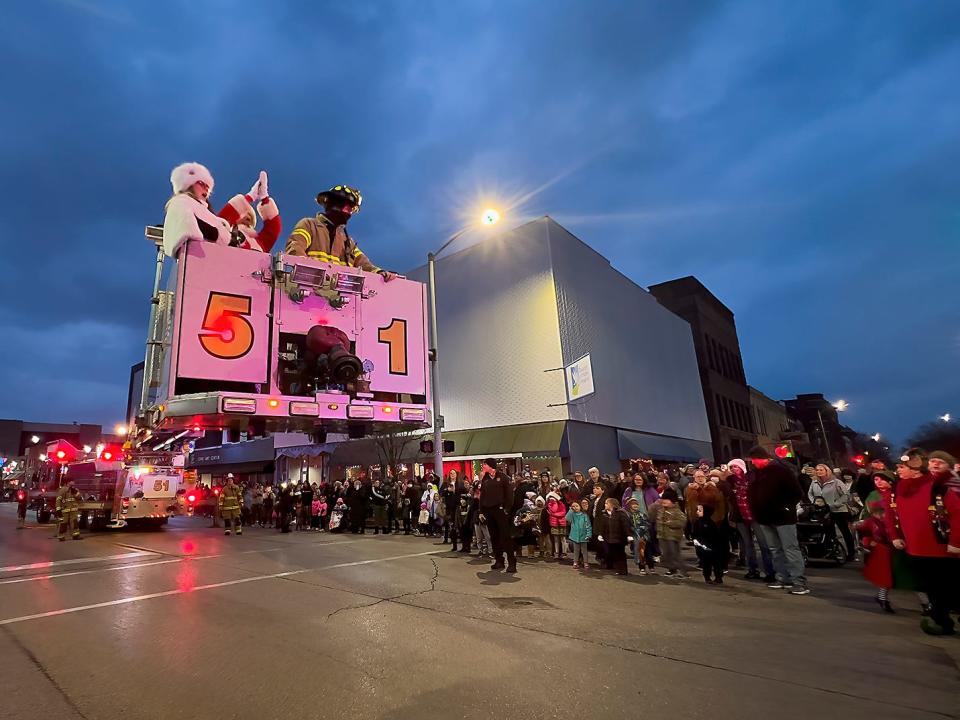 Santa and Mrs. Claus wave to the crowd after being rescued from the rooftop of the First Mid Bank & Trust building just before the Galesburg Downtown Community Partnership Holly Days Parade on Sunday, Dec. 5, 2021.