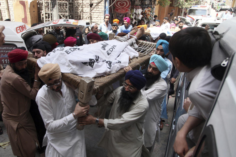 Pakistani Sikhs carry the body of a Sikh who was killed by gunmen in Peshawar, Pakistan, Sunday, May 15, 2022. Police officer Ejaz Khan said gunmen on a motorcycle opened fire on two members of the minority Sikh community in a bazaar in the Peshawar suburb of Sarband. (AP Photo/Mohammad Zubair)