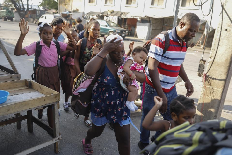 Residents flee their homes during clashes between police and gang member at the Portail neighborhood in Port-au-Prince, Haiti, Thursday, Feb. 29, 2024. Gunmen shot at the international airport and other targets in a wave of violence that forced businesses, government agencies and schools to close early. (AP Photo/Odelyn Joseph)