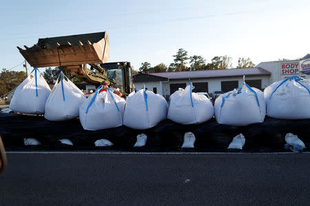 Members of the National Guard work on a long sand bag flood barrier being built by the South Carolina Department of Transportation on U.S. 501 to lesson damage to roads anticipated from floods caused by Hurricane Florence, now downgraded to a tropical depression, in Conway, South Carolina, U.S. September 19, 2018. REUTERS/Randall Hill