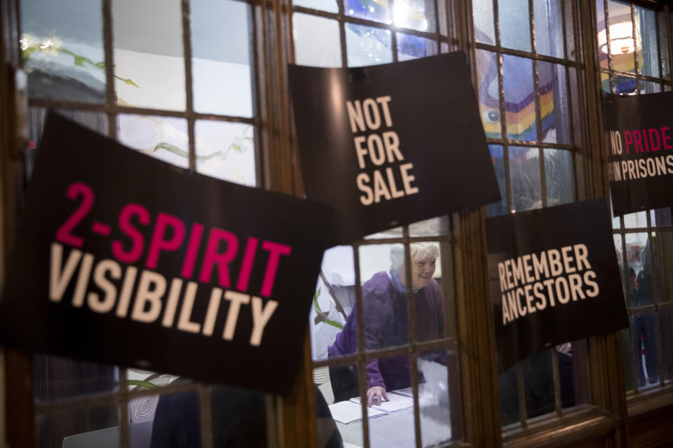 In this Wednesday, March 27, 2019, photo, a participant checks in as she arrives for a meeting of the Reclaim Pride Coalition at the Church of the Village in New York. Activists who believe New York City’s annual LGBTQ Pride march has become too commercialized are staging an alternative march the same day. The two marches through Manhattan streets will take place Sunday, June 30, the last day of a month of celebrations marking the 50th anniversary of the 1969 Stonewall uprising. (AP Photo/Mary Altaffer)