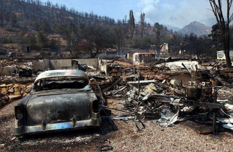 FILE - Damage from the Coal Seam fire in Glenwood Springs, Colo., is shown on June 9, 2002, An area outside Denver where Colorado's most destructive in history wildfire burned 1,000 homes last month is home to numerous abandoned coal mines that authorities say could be a potential cause of the wind-driven wildfire. History shows that the moldering coal have started fires before, including near the same location south of Boulder in 2005, when a hot vent from a burning mine sparked a brush fire that was quickly extinguished. A coal mine fire also ignited a blaze in the Colorado mountain town of Glenwood Springs that burned 29 homes in 2002. (AP Photo/ Peter M. Fredin, File)