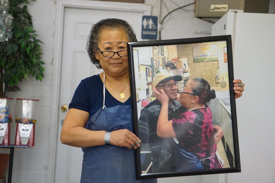 Owner Sun Thompson holds a picture of herself and her husband, James Charles Thompson, who died in June 2021. Chang's Fish Market, 110 Johnson St., Fayetteville.