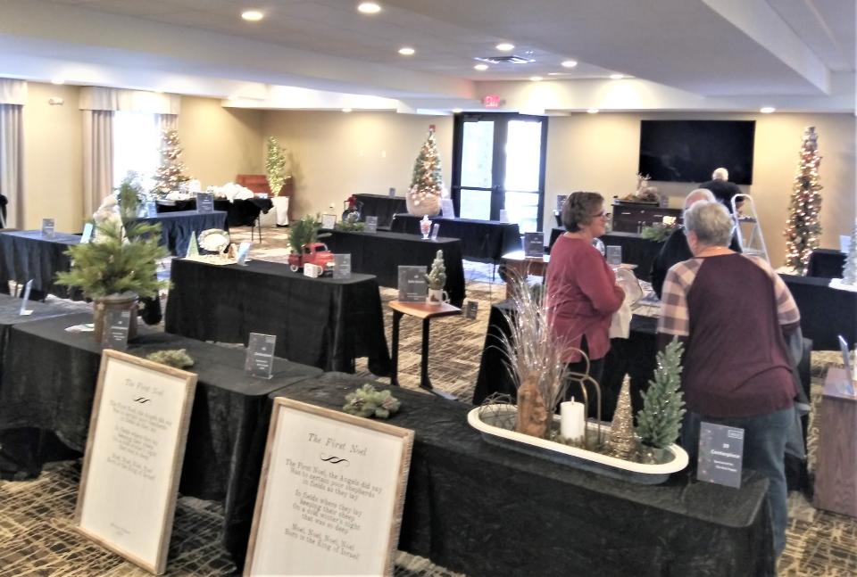 Volunteers from the Pomerene Hospital Auxiliary help transform the banquet room at the Berlin Grande Hotel into the home of the Pomerene Hospital Christmas Tree Festival that takes place Friday and Saturday in Berlin.