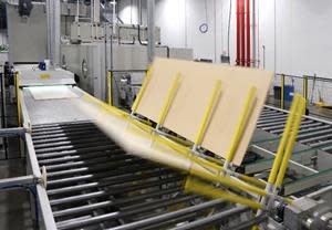 Primed medium-density fiberboard is transported down the automated production line.