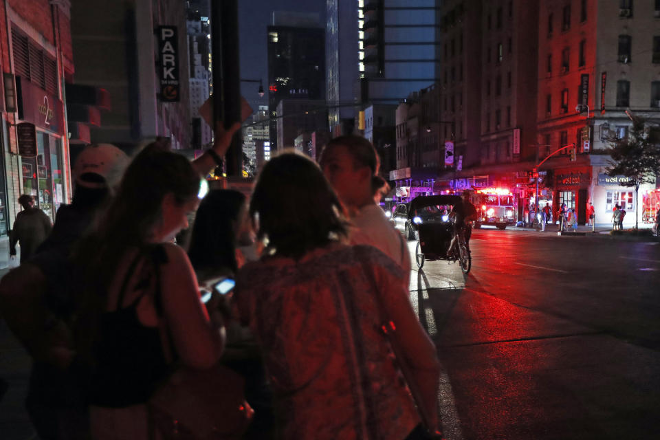 People gather in midtown Manhattan during a widespread power outage, Saturday, July 13, 2019, in New York. Authorities were scrambling to restore electricity to Manhattan following a power outage that knocked out Times Square's towering electronic screens, darkened marquees in the theater district and left businesses without electricity, elevators stuck and subway cars stalled. (AP Photo/Michael Owens)