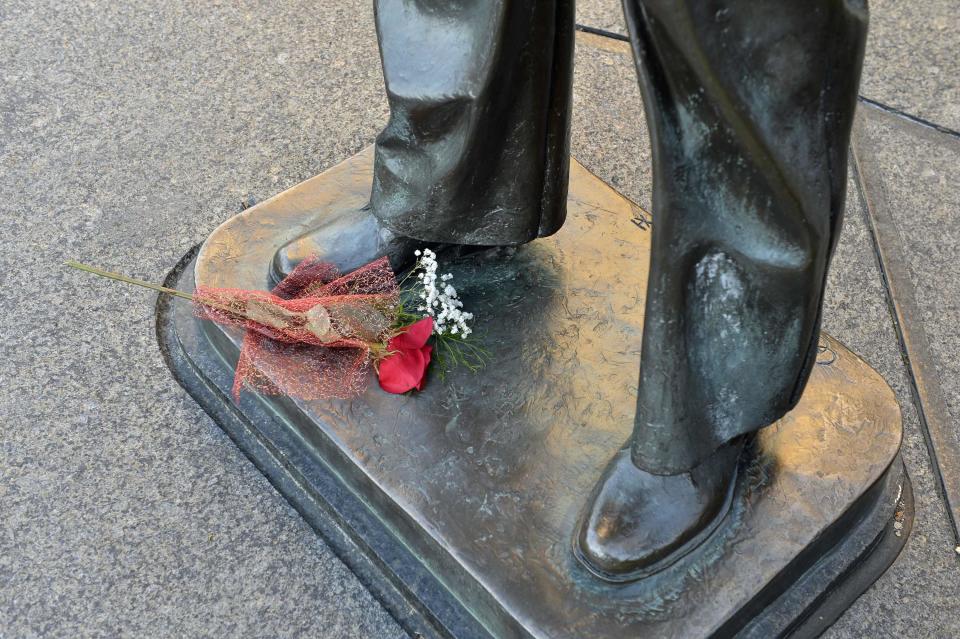 A lone bouquet of flowers is left at the base of a statue at the Navy Memorial in Washington, to honor the victims of the attack at the Navy Yard