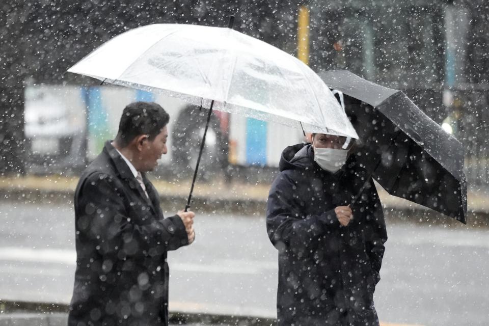 People walk at a street in the snow Monday, Feb. 5, 2024, in Tokyo. Japan Meteorological Agency warns more metropolitan areas braced for snowfall Monday. (AP Photo/Eugene Hoshiko)