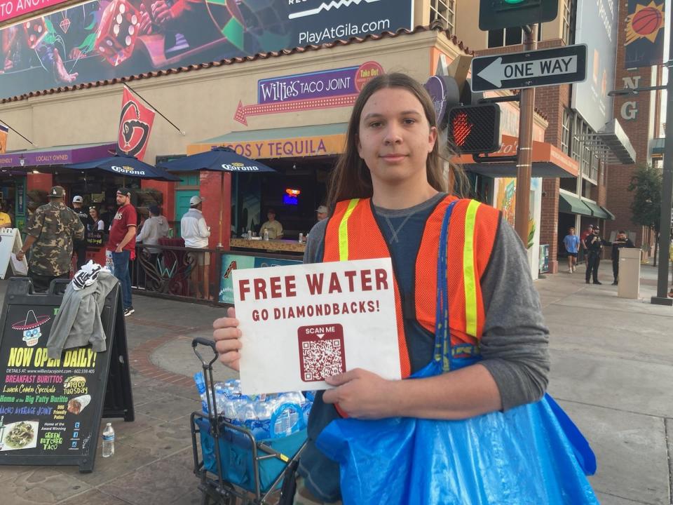 Yousef Isaac, of the Muslim American Society, hands out free water at the corner of Jefferson and 2nd streets just before Game 5 of the World Series between the Arizona Diamondbacks and Texas Rangers on Wednesday, Nov. 1, 2023 at Chase Field in Phoenix.