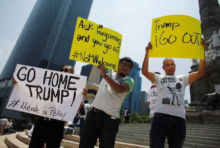 Demonstrators hold placards during a protest against the visit of U.S. Republican presidential candidate Donald Trump, at the Angel of Independence monument in Mexico City, Mexico, August 31, 2016. REUTERS/Tomas Bravo