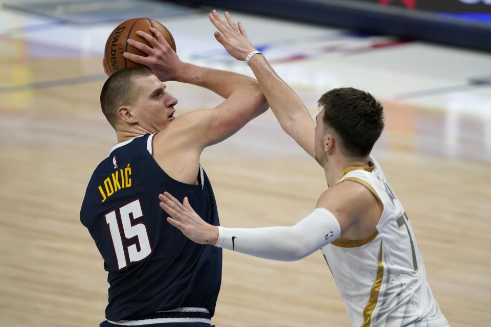 Denver Nuggets center Nikola Jokic (15) attempts to pass the ball as Dallas Mavericks guard Luka Doncic, right, defends in the second half of an NBA basketball game in Dallas, Monday, Jan. 25, 2021. (AP Photo/Tony Gutierrez)