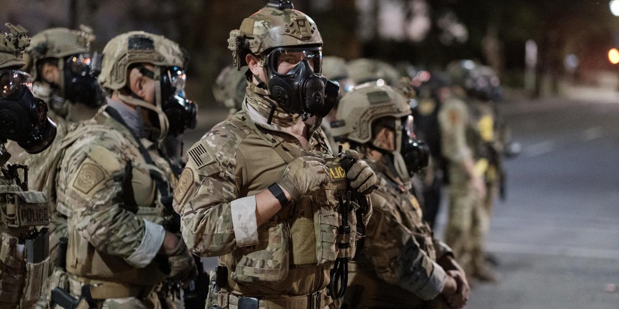 In this photo provided by Doug Brown, agents from different components of the Department of Homeland Security are deployed to protect a federal courthouse in Portland, Ore., Sunday, July 5, 2020. Protesters who have clashed with authorities in Portland are facing off not just against city police but a contingent of federal agents who reflect a new priority for the Department of Homeland Security: preventing what President Donald Trump calls "violent mayhem." The agents clad in military-style uniforms include members of an elite Border Patrol tactical unit, and their deployment to protect federal buildings and monuments is a departure for an agency created to focus on threats from abroad. (Doug Brown via AP)