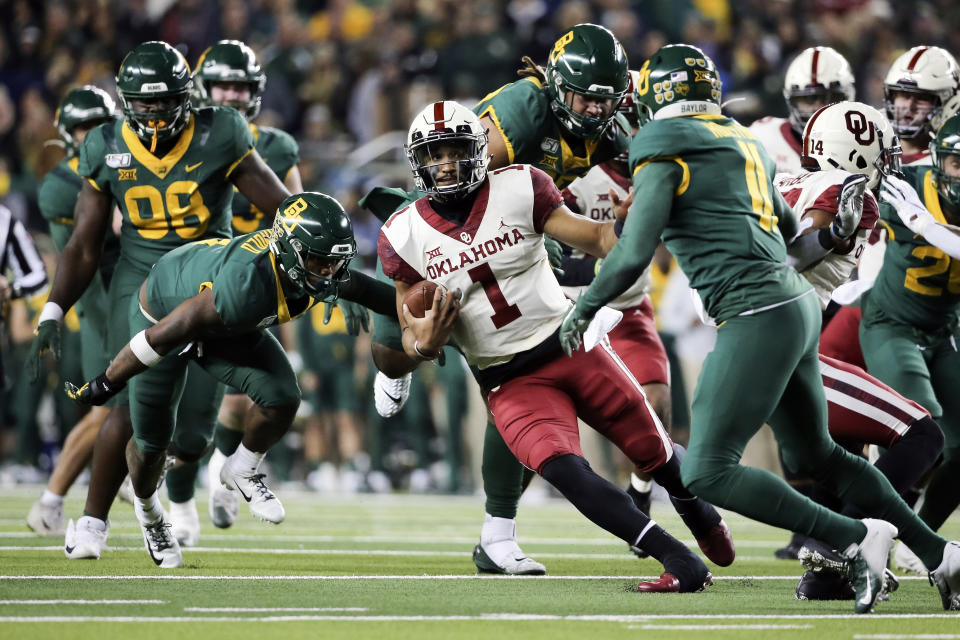 Oklahoma quarterback Jalen Hurts (1) carries the ball as he cuts back on Baylor cornerback Jameson Houston, right, during the second half of an NCAA college football game in Waco, Texas, Saturday, Nov. 16, 2019. Oklahoma won 34-31. (AP Photo/Ray Carlin)