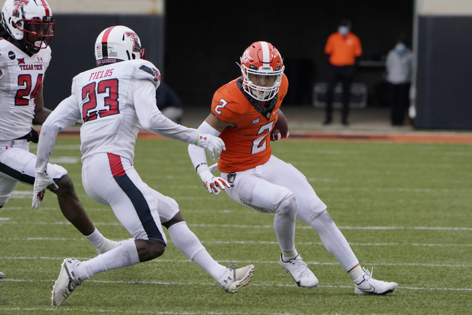 Oklahoma State wide receiver Tylan Wallace (2) carries past Texas Tech defensive back DaMarcus Fields (23) in the second half of an NCAA college football game in Stillwater, Okla., Saturday, Nov. 28, 2020. (AP Photo/Sue Ogrocki)