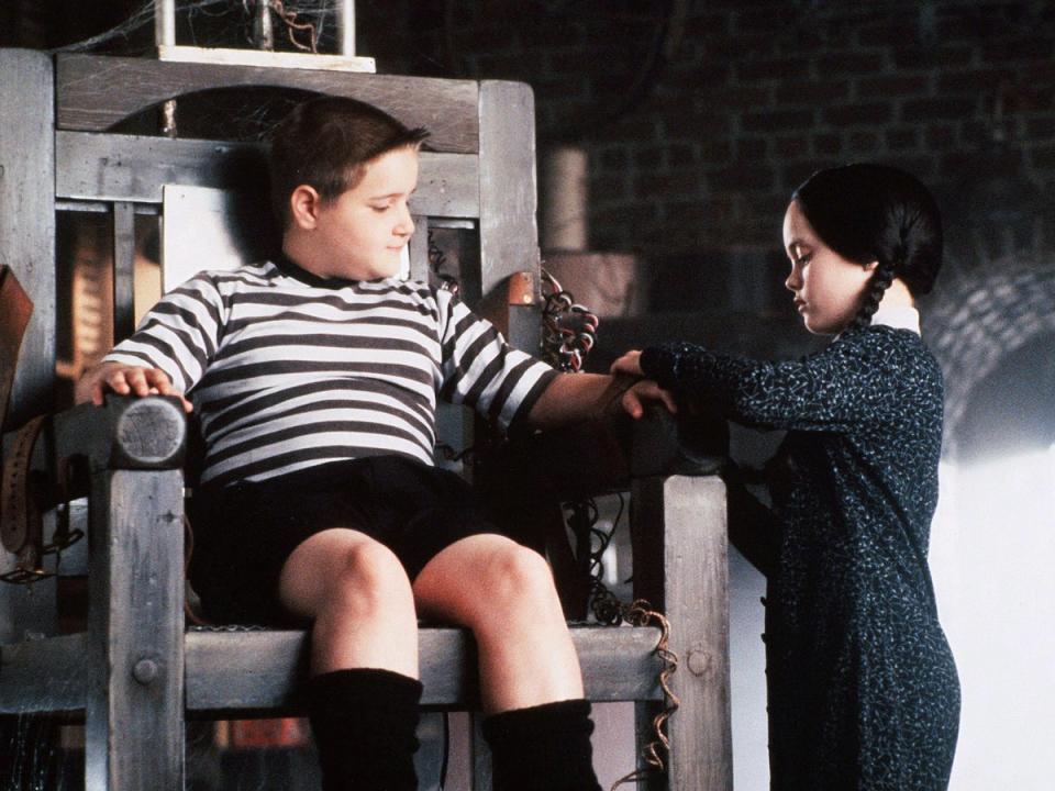 Christina Ricci’s Wednesday straps her brother Pugsley (Jimmy Workman) into an electric chair in ‘The Addams Family’ (Shutterstock)