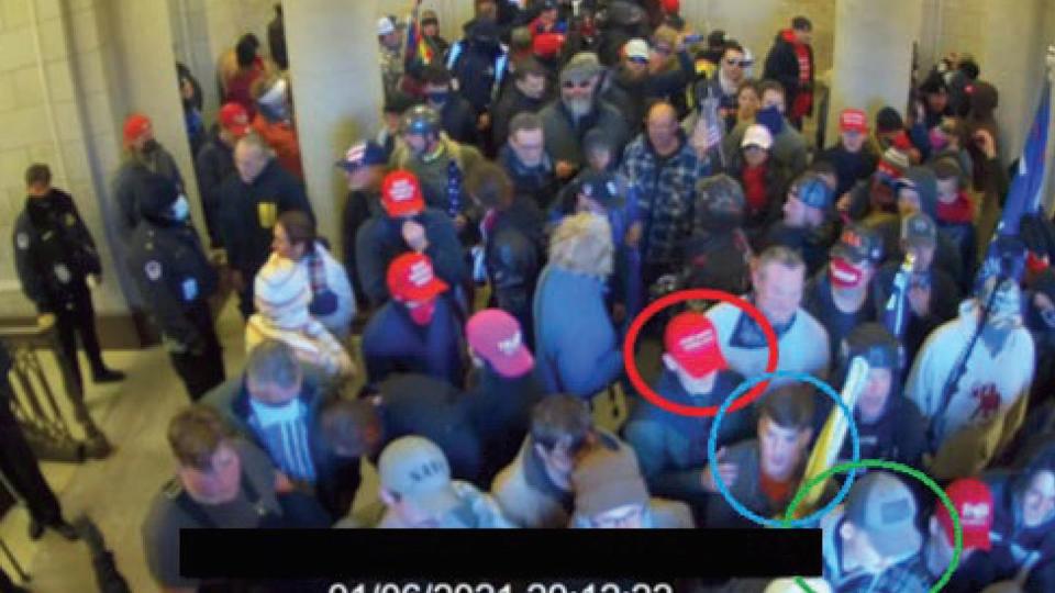 In this image from U.S. Capitol Police video, released and annotated by the Justice Department in the Statement of Facts supporting an arrest warrant, Joshua Abate, circled in green, Micah Coomer, circled in red, and Dodge Dale Hellonen, circled in blue, appear inside the U.S. Capitol on Jan. 6, 2021, in Washington. (Justice Department via AP)