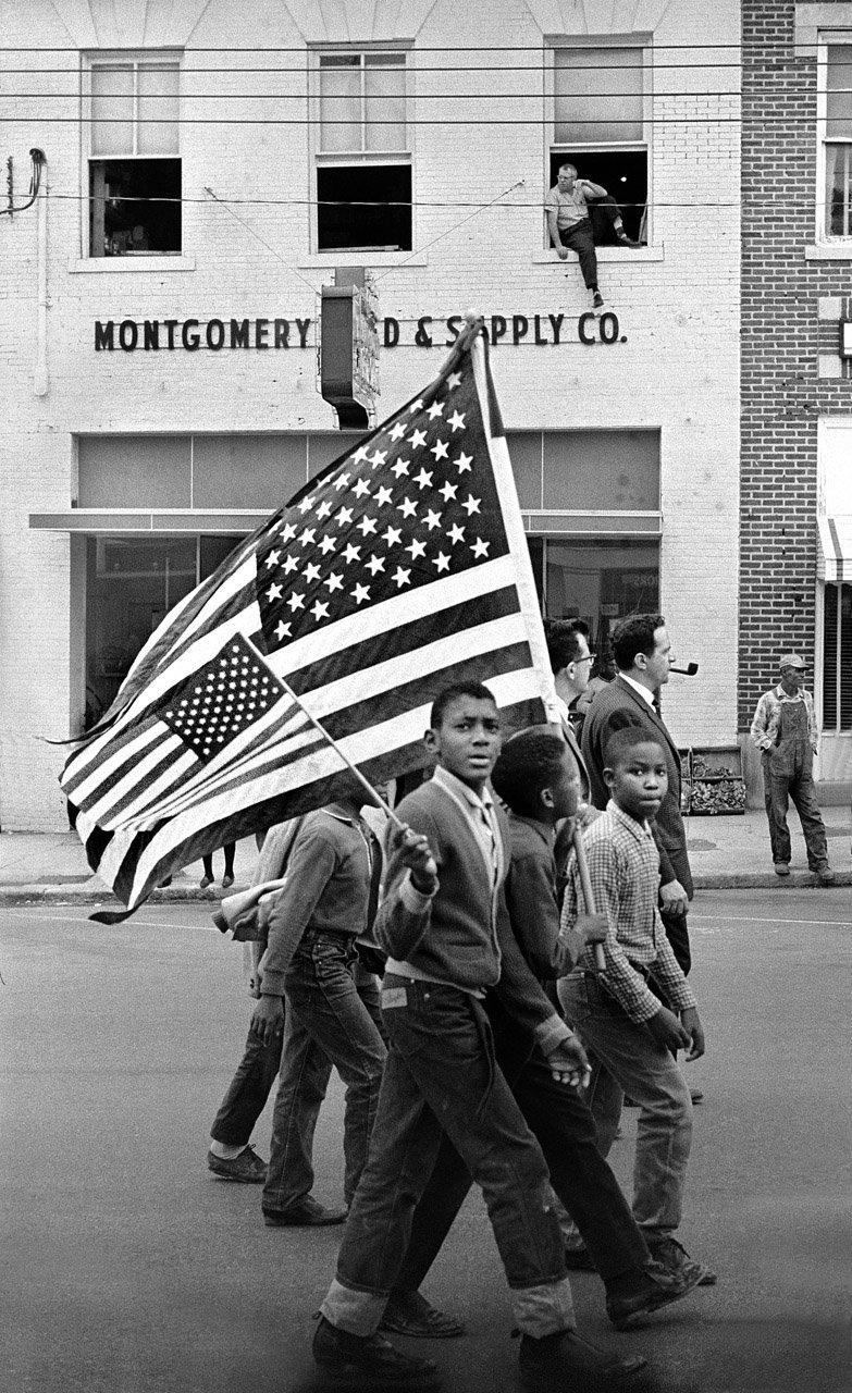 Young civil rights marchers with American flags march in Montgomery, 1965.