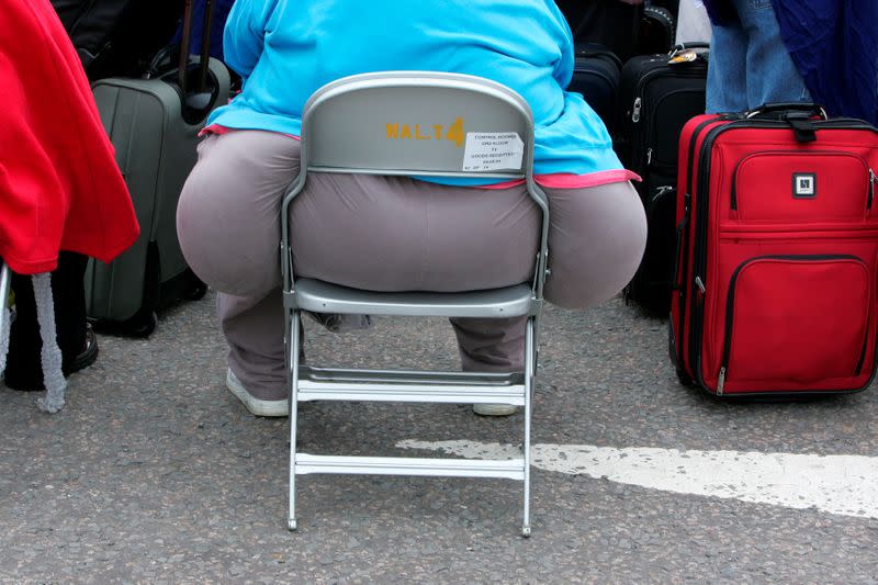 FILE PHOTO: A passenger waits for a delayed flight at Heathrow airport's terminal four in London