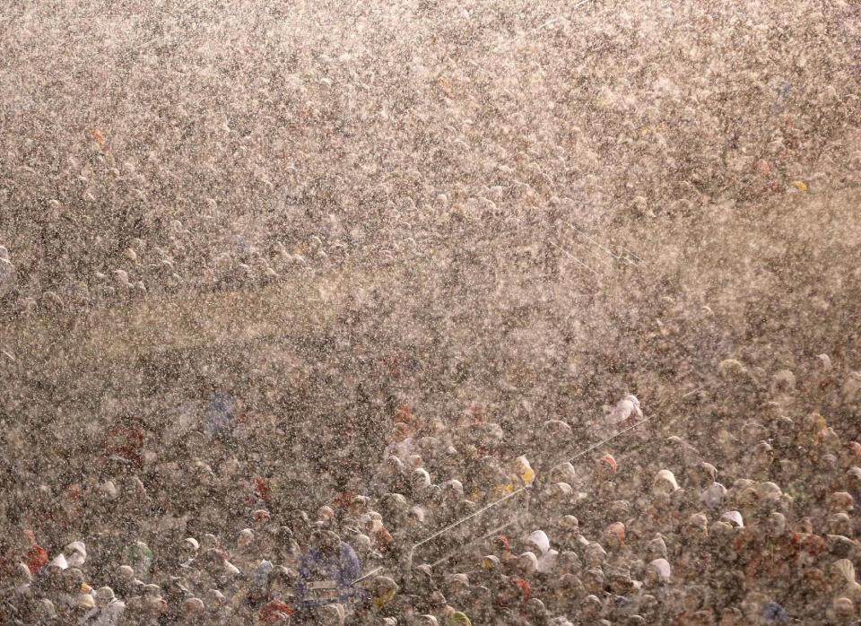 Hockey fans watch the Chicago Blackhawks face the Pittsburgh Penguins as snow falls during the first period of an NHL Stadium Series hockey game at Soldier Field on Saturday, March 1, 2014, in Chicago. (AP Photo/Charles Rex Arbogast)