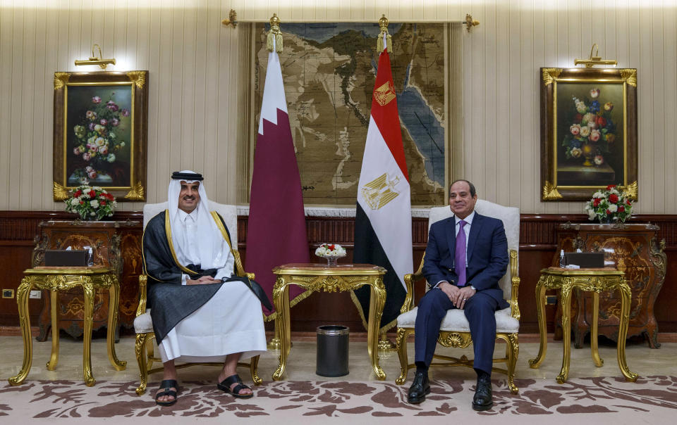 In this photo made available by Qatar News Agency, QNA, Qatari Emir Tamim bin Hamad Al Thani, left, meets with Egyptian President Abdel-Fattah el-Sissi upon his arrival at Cairo airport, Egypt, Friday, June 24, 2022. Qatar's emir arrived in Cairo to hold talks with Egypt's president in his first visit since the two countries agreed to reset relations after more than seven years of diplomatic animosity. (QNA via AP)