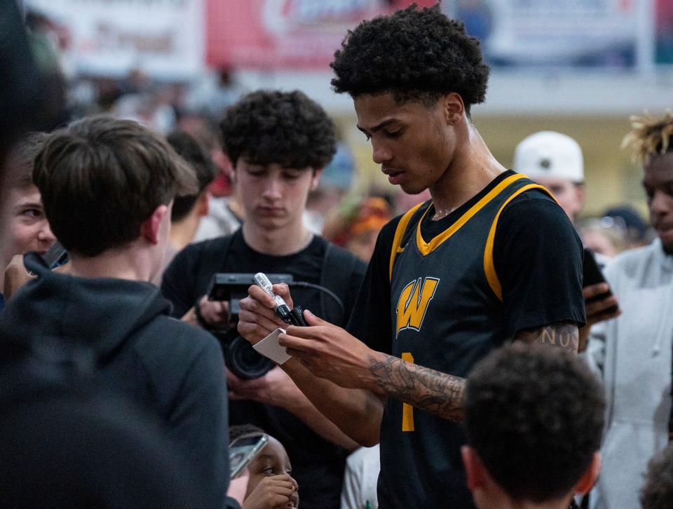 Archbishop Wood's Jalil Bethea (1) signs autographs for young fans after the Vikings' state playoff win against Lower Merion.