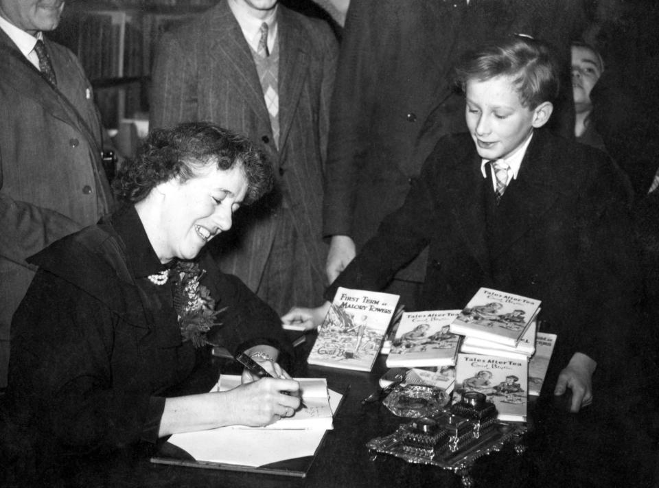 Popular author of children's books, Enid Blyton in Hatchards, Piccadilly, London, where she gave a talk 'for children only', adults not being admitted. Afterwards she autographed copies of her books for her young audience. She obliges "Oliver Twist" (John Howard Davies who played the film part) with a signed copy of one of her books.   (Photo by PA Images via Getty Images)