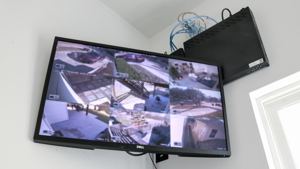 A monitor connected to a Reolink NVR showing a number of feeds from various security cameras