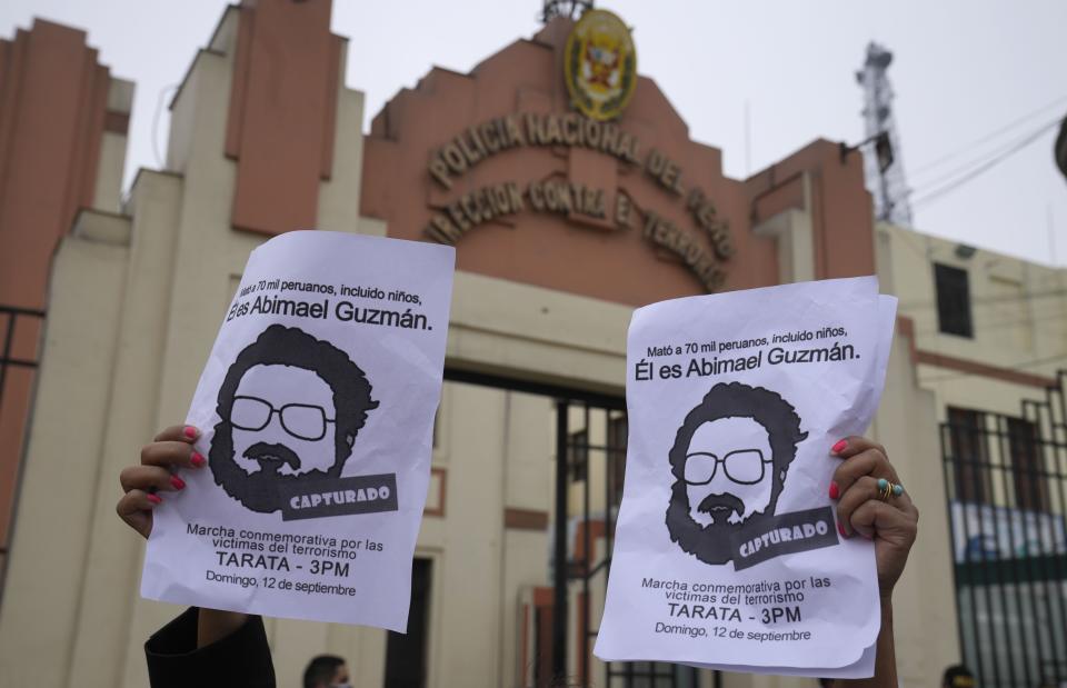 People gather outside the anti-terrorism directorate to celebrate the death of Abimael Guzman, founder and leader of the Shining Path guerrilla movement, in Lima, Peru, Saturday, Sept. 11, 2021. Guzman, who was captured in 1992, died on Saturday in a military hospital after an illness, the Peruvian government said. He was 86. (AP Photo/Martin Mejia)