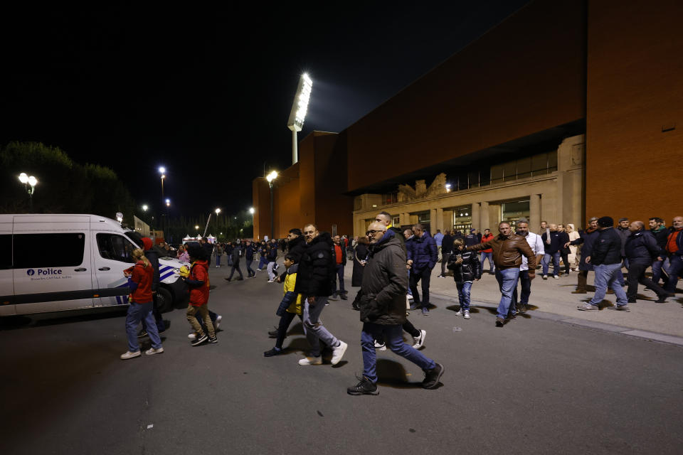 Aficionados abandonan el estadio en la noche después de que el encuentro ente Bélgica y Suecia del la eliminatoria a la Euro se suspendiera tras un ataque terrorista en Bruselas el lunes 16 de octubre del 2023. (AP Foto/Geert Vanden Wijngaert)