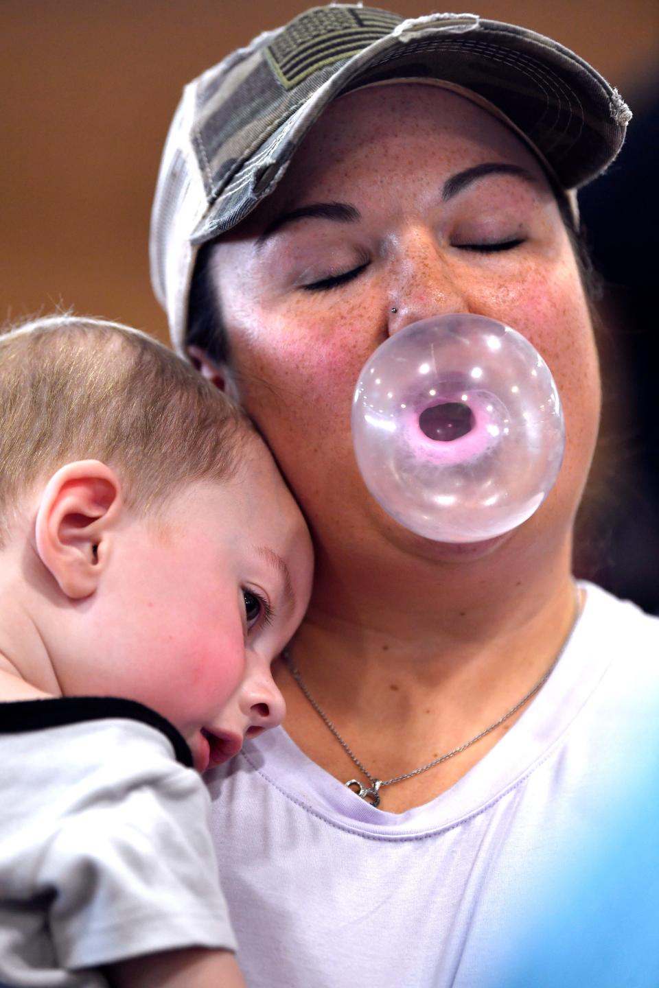 Kayla Dennison holds her 20-month-old son Brantley as she competes in Tuesday's Bubble Gum Contest.