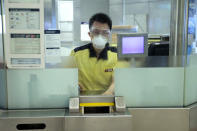 A staff member of the MTR wears mask as demonstrators stage a protest at the Yuen Long MTR station in Hong Kong, Wednesday, Aug. 21, 2019. Hong Kong riot police faced off briefly with protesters occupying a suburban train station Wednesday evening following a commemoration of a violent attack there by masked assailants on supporters of the anti-government movement. (AP Photo/Kin Cheung)