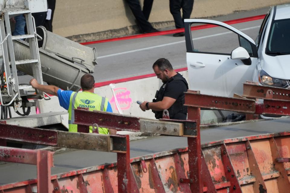 Police talk to construction workers as they investigate the aftermath of a police shooting June 20 on Interstate 43 in Milwaukee.
