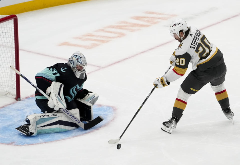 Vegas Golden Knights center Chandler Stephenson (20) loses control of the puck while trying to shoot on Seattle Kraken goaltender Philipp Grubauer (31) during the third period of an NHL hockey game Thursday, April 13, 2023, in Seattle. The Golden Knights won 3-1. (AP Photo/Lindsey Wasson)