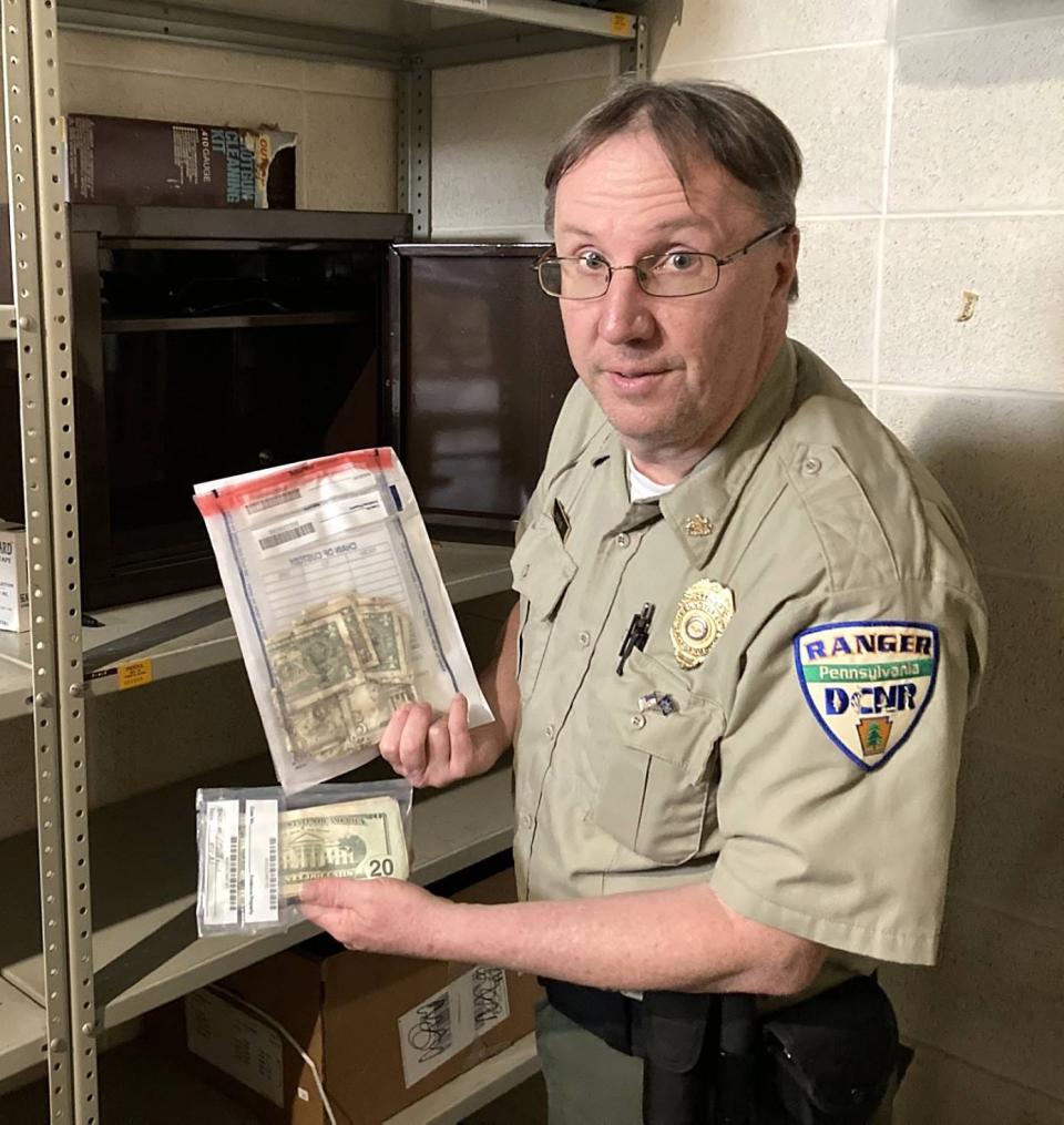 Bryan Hogan, Presque Isle State Park manager supervisor, shows some of the cash that has been found at the park in recent years. Money is kept in a safe, inside a locked room.