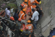 A man is rescued from the debris after a residential building collapsed in Bhiwandi in Thane district, a suburb of Mumbai, India, Monday, Sept.21, 2020. (AP Photo/Praful Gangurde)