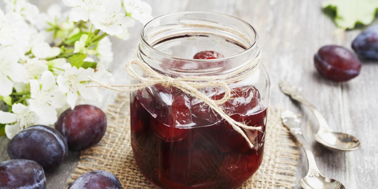 plum jam in a glass jar on the wooden table